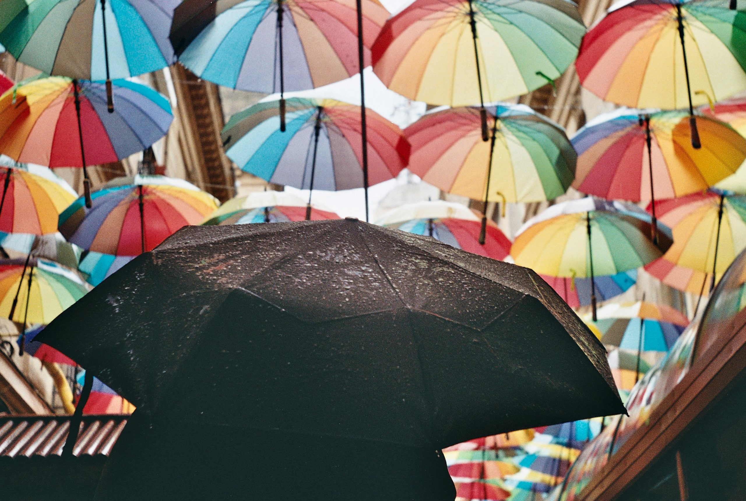 a big black umbrella with smaller multi-colored umbrellas around it.